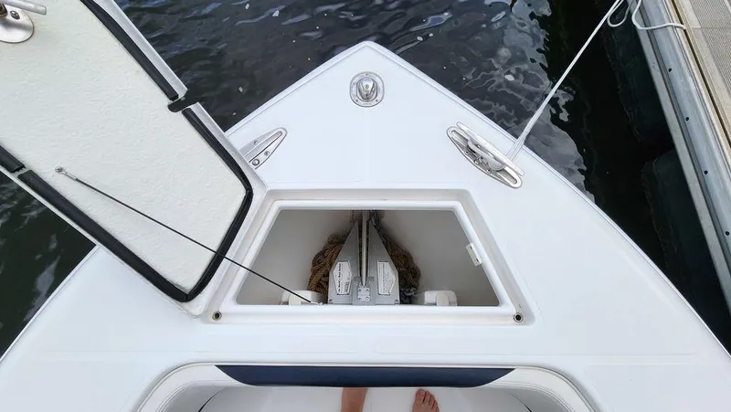 Slide: The Image of 2015 Bluewater 2550 boat anchor compartment, open hatch, docked on water. - 11