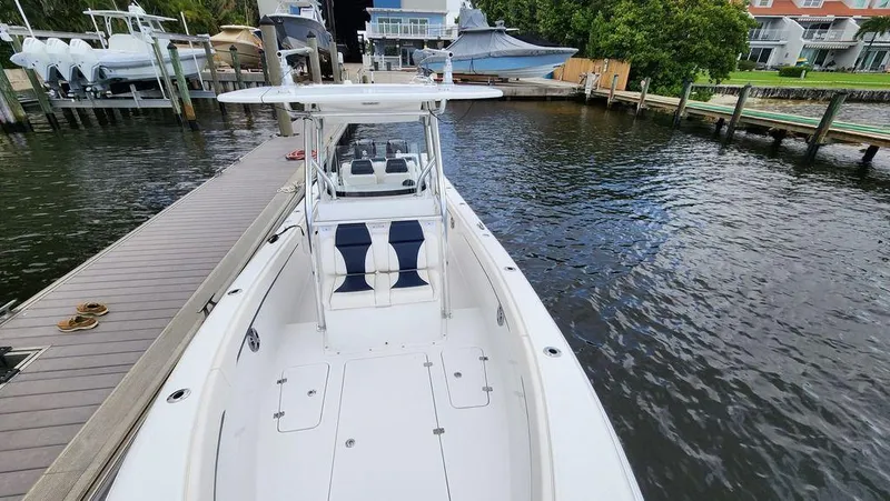 Slide: The Image of 2015 Bluewater 2550 boat docked at marina, showcasing spacious deck and seating. - 12