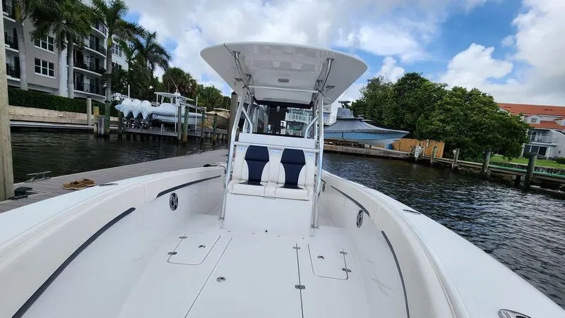 Slide: The Image of 2015 Bluewater 2550 boat docked by waterfront homes, clear sky above. - 13