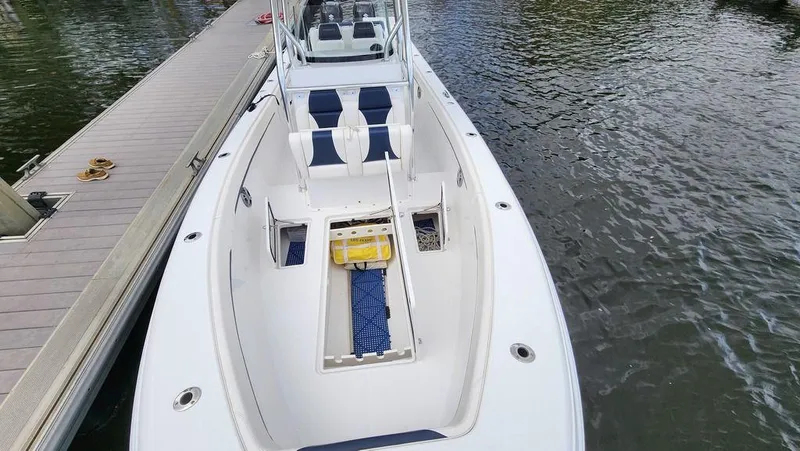 Slide: The Image of 2015 Bluewater 2550 boat docked, featuring spacious deck and seating. - 15