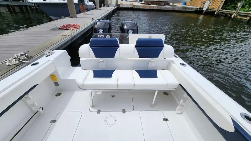 Slide: The Image of 2015 Bluewater 2550 boat with dual Suzuki 175 engines docked by the water. - 17