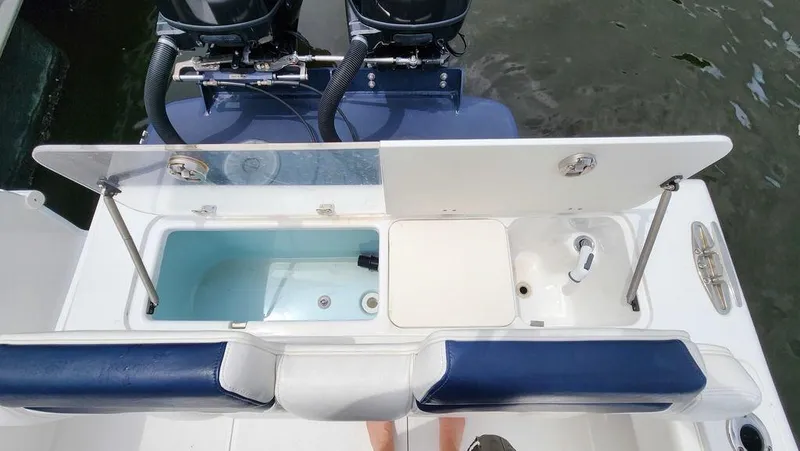 Slide: The Image of 2015 Bluewater 2550 boat with open storage compartments and dual engines. - 18