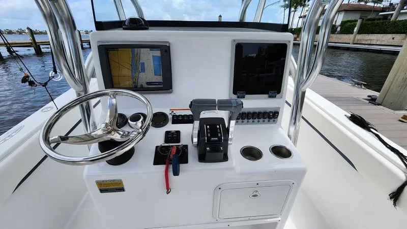 Slide: The Image of 2015 Bluewater 2550 boat console with steering wheel, navigation screens, and controls. - 22