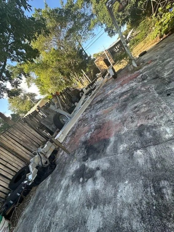 Slide: The Image of Outdoor area with trees and a Bluewater 2550 boat trailer, 2015 model, on a concrete surface. - 30