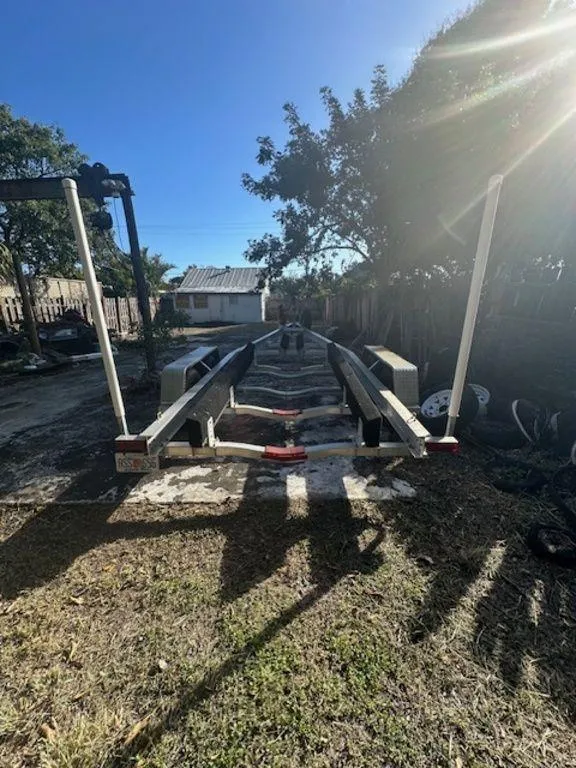 Slide: The Image of 2015 Bluewater 2550 boat trailer parked outdoors in a sunny yard. - 37