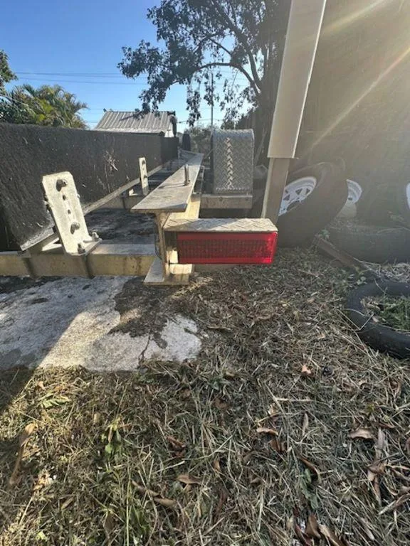 Slide: The Image of Boat trailer for 2015 Bluewater 2550, parked on grass with spare tires nearby. - 39