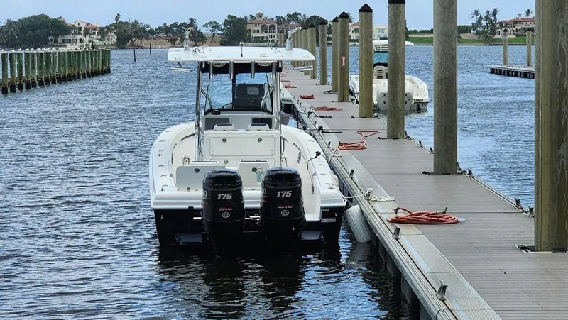 Slide: The Image of 2015 Bluewater 2550 boat docked with twin 175 engines, calm marina setting. - 4