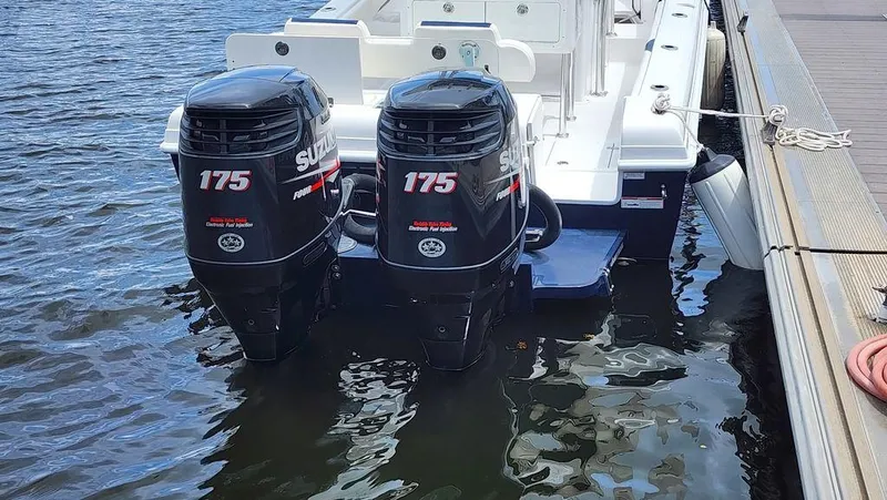 Slide: The Image of 2015 Bluewater 2550 boat with twin Suzuki 175 outboard motors docked on water. - 5