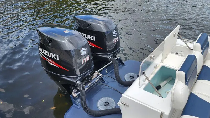 Slide: The Image of Twin Suzuki 175 outboard motors on a 2015 Bluewater 2550 boat, docked on water. - 6