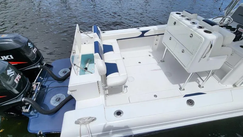 Slide: The Image of 2015 Bluewater 2550 boat with dual Suzuki engines, spacious deck, and seating on water. - 7