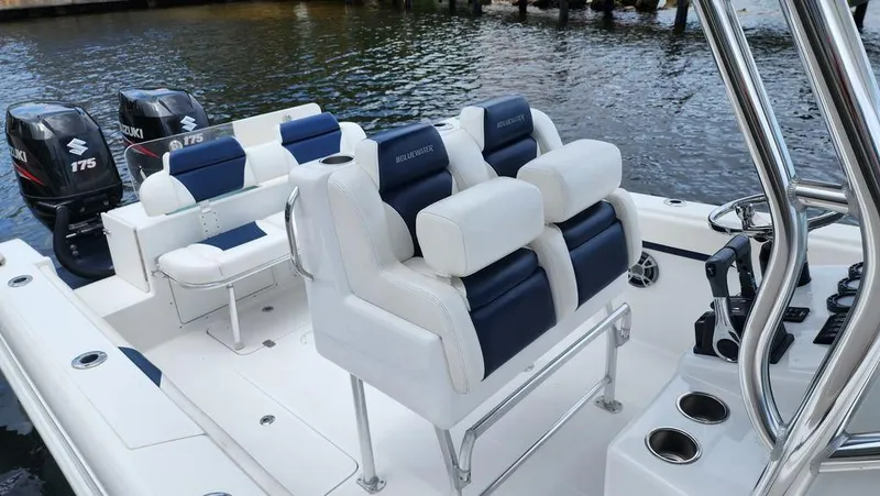 Slide: The Image of 2015 Bluewater 2550 boat interior with dual Suzuki 175 engines, white and blue seating. - 8