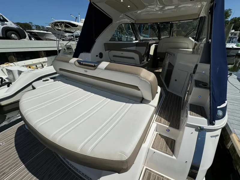Slide: The Image of 2016 Regal 35 Sport Coupe boat interior with seating and steps, docked at marina. - 11