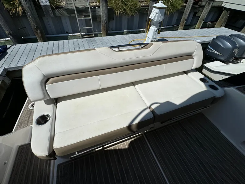 Slide: The Image of Regal 35 Sport Coupe 2016 boat seating area with cup holders, docked at marina. - 12