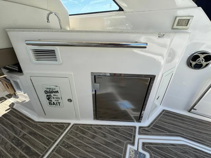 Slide: The Image of 2016 Regal 35 Sport Coupe interior with kitchenette and humorous sign. - 18