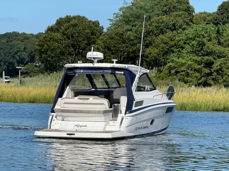 Slide: The Image of 2016 Regal 35 Sport Coupe boat cruising on a serene lake. - 5