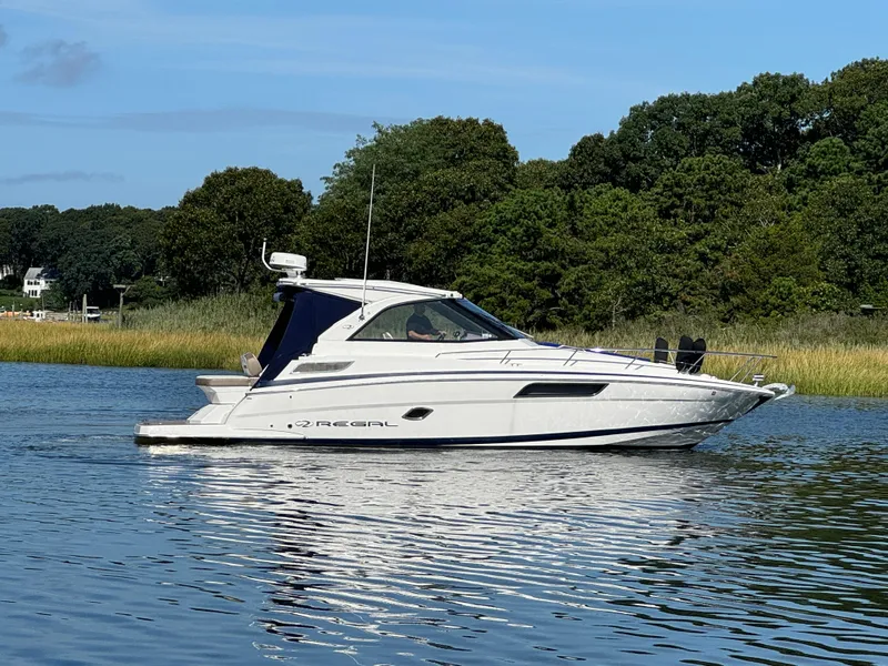 Slide: The Image of 2016 Regal 35 Sport Coupe cruising on a serene lake. - 6