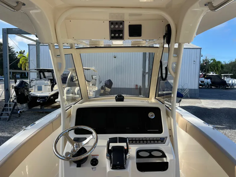 Slide: The Image of 2025 Scout 277 LXF boat helm with steering wheel and control panel. - 11