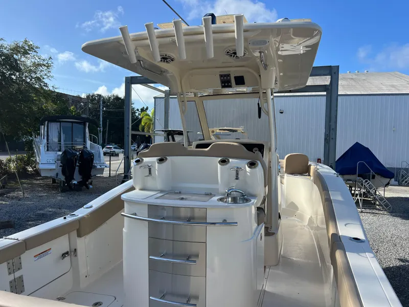 Slide: The Image of 2025 Scout 277 LXF boat with sleek design and modern amenities in a marina setting. - 6