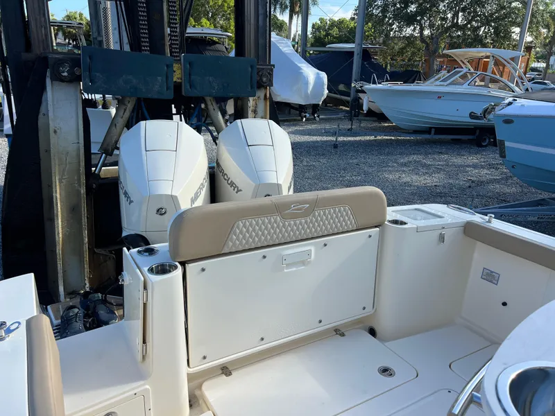 Slide: The Image of 2025 Scout 277 LXF boat with dual Mercury engines in a marina setting. - 8