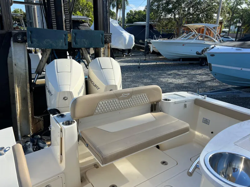Slide: The Image of 2025 Scout 277 LXF boat with dual Mercury engines, docked in a marina. - 9