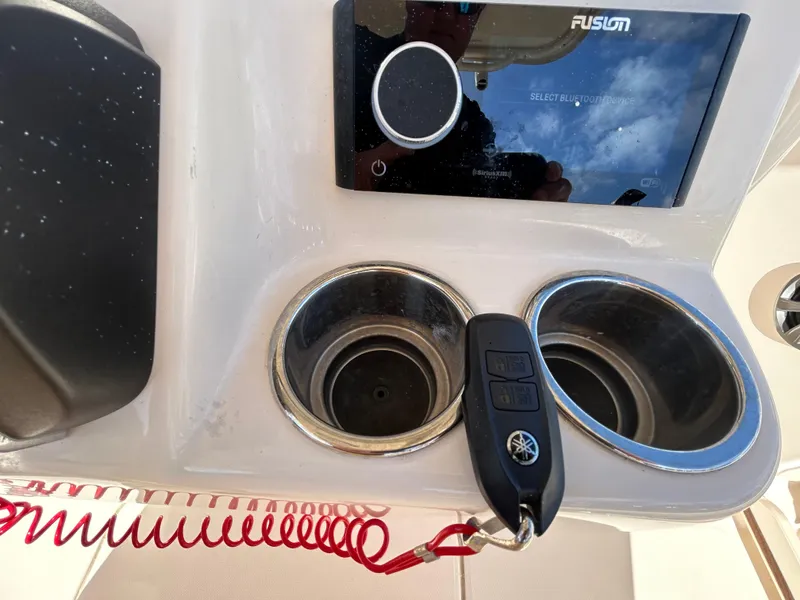 Slide: The Image of 2021 Grady-White Fisherman 216 console with Fusion stereo, cup holders, and Yamaha key fob. - 12