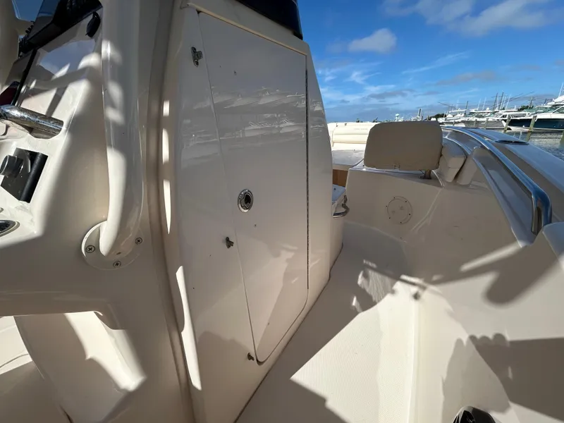 Slide: The Image of 2021 Grady-White Fisherman 216 boat interior with seating and storage, docked under blue sky. - 18