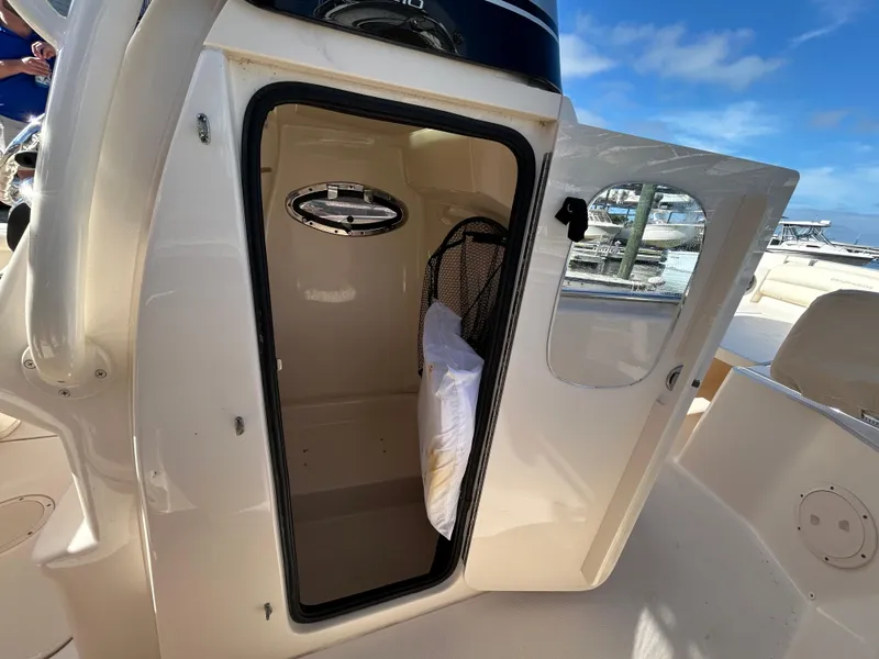 Slide: The Image of 2021 Grady-White Fisherman 216 boat storage compartment with open door, showcasing interior space. - 19