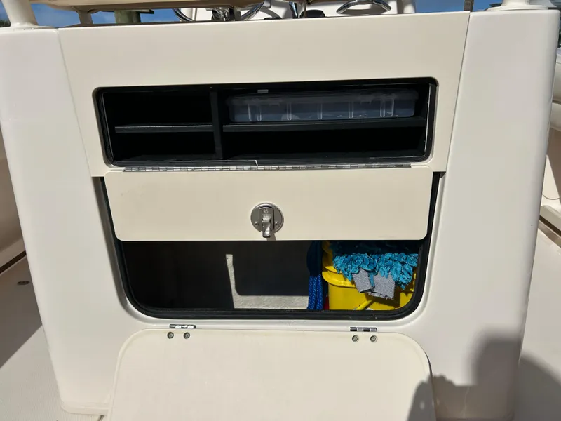 Slide: The Image of 2021 Grady-White Fisherman 216 storage compartment with lock and cleaning supplies. - 21