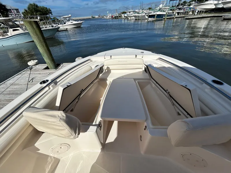 Slide: The Image of 2021 Grady-White Fisherman 216 boat interior at marina, showcasing seating and storage. - 25