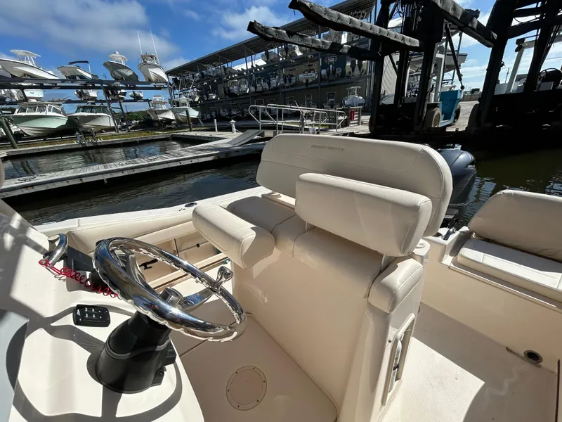 Slide: The Image of 2021 Grady-White Fisherman 216 boat interior at marina, featuring steering wheel and seating. - 8