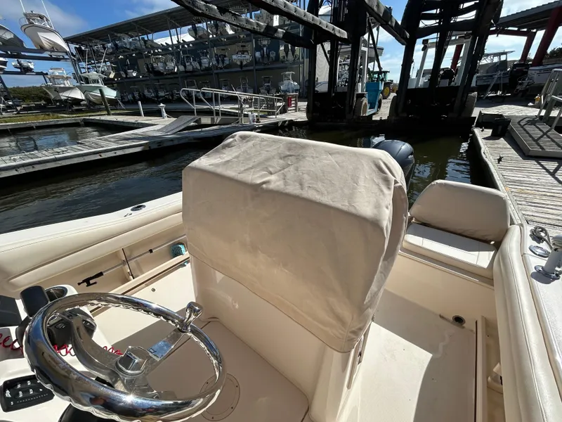 Slide: The Image of 2021 Grady-White Fisherman 216 boat interior at marina, featuring steering wheel and covered seat. - 9