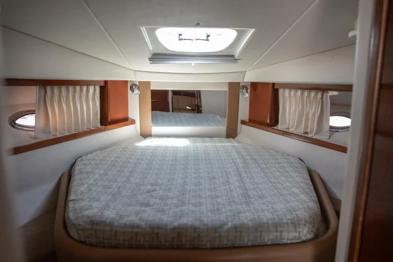 Slide: The Image of Luxurious cabin interior of 2008 Sea Ray 380 Sundancer yacht with cozy bed and porthole windows. - 13