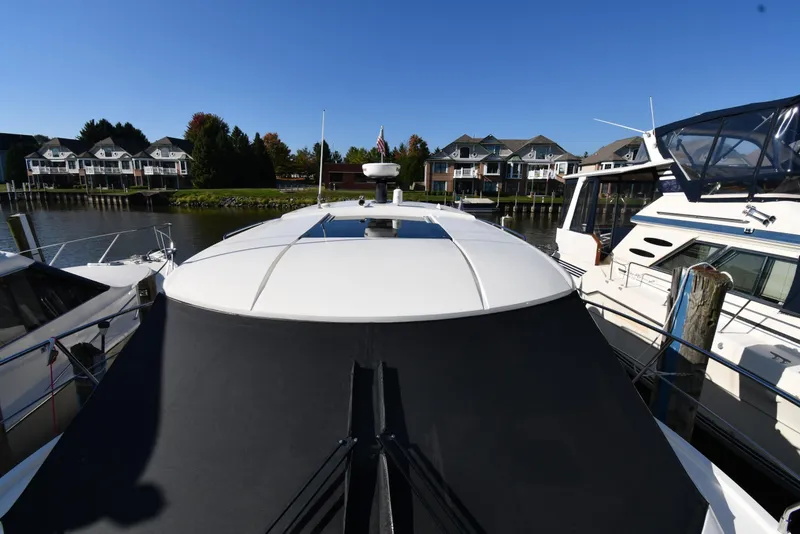 Slide: The Image of 2017 Carver C37 Coupe yacht docked in a marina with waterfront homes. - 10