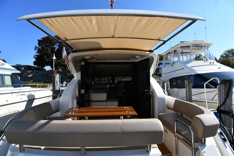 Slide: The Image of 2017 Carver C37 Coupe yacht with open deck and seating area at marina. - 12