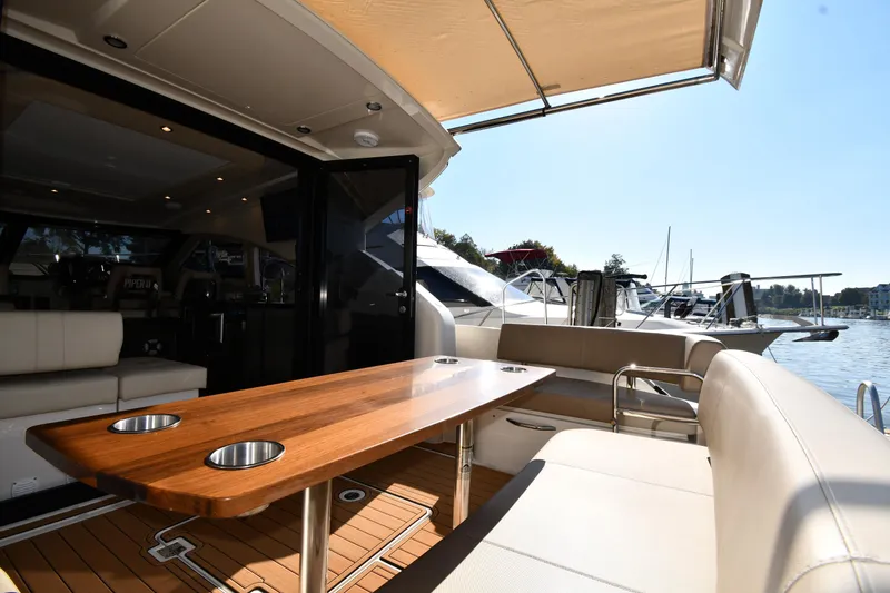 Slide: The Image of Luxurious 2017 Carver C37 Coupe yacht interior with elegant seating and wooden table. - 16