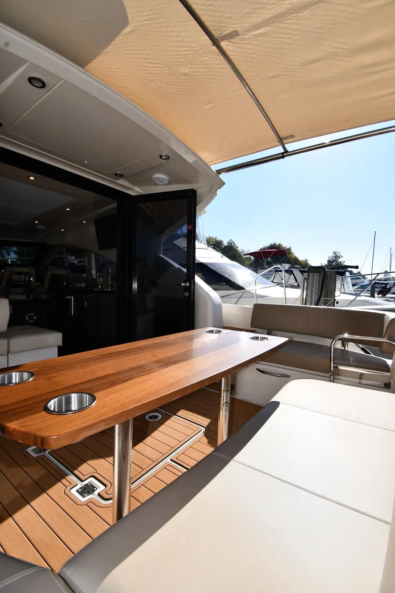 Slide: The Image of 2017 Carver C37 Coupe yacht interior with wooden table and seating area. - 17