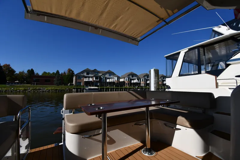 Slide: The Image of Carver C37 Coupe 2017 yacht deck with seating, table, and waterfront view. - 20