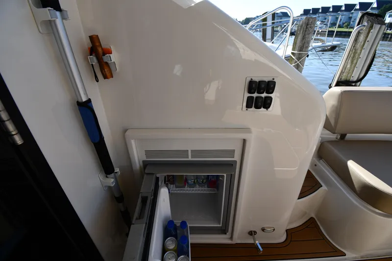 Slide: The Image of 2017 Carver C37 Coupe yacht interior with open mini fridge and control panel. - 22