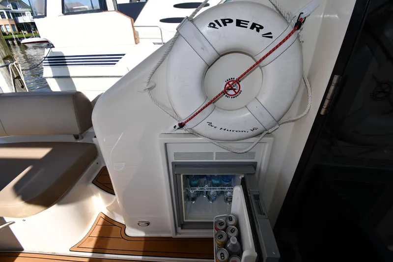 Slide: The Image of Carver C37 Coupe 2017 yacht with life preserver and open mini fridge on deck. - 23