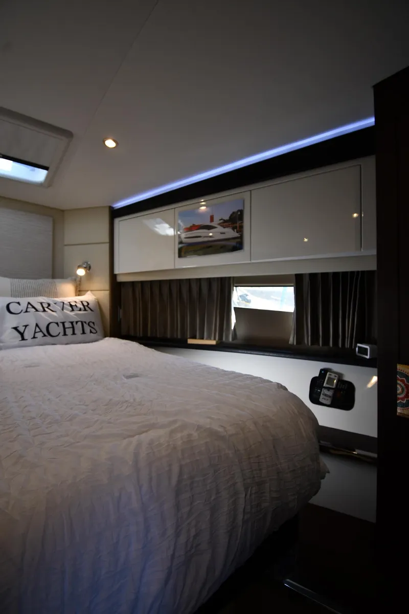 Slide: The Image of Interior of 2017 Carver C37 Coupe yacht bedroom with modern design and cozy bedding. - 27