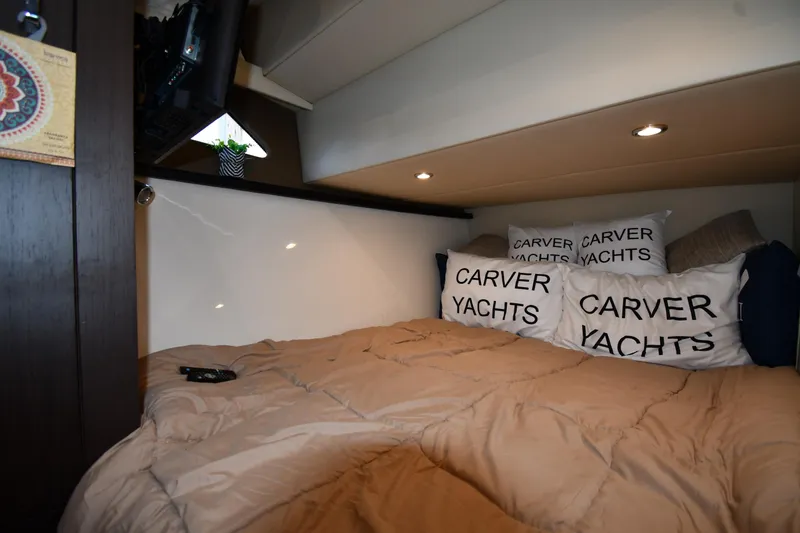 Slide: The Image of Cozy cabin interior of 2017 Carver C37 Coupe yacht with branded pillows and bedding. - 37