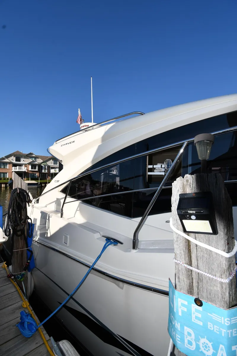 Slide: The Image of 2017 Carver C37 Coupe yacht docked at marina under clear blue sky. - 4