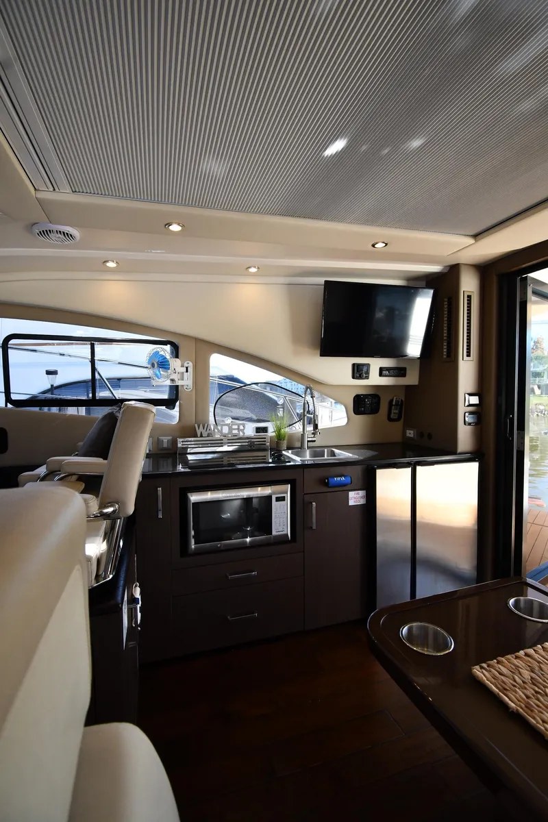 Slide: The Image of Interior of 2017 Carver C37 Coupe yacht with modern kitchen and seating area. - 48