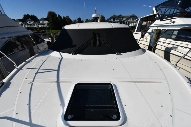 Slide: The Image of 2017 Carver C37 Coupe yacht docked at marina, showcasing sleek design and spacious deck. - 8