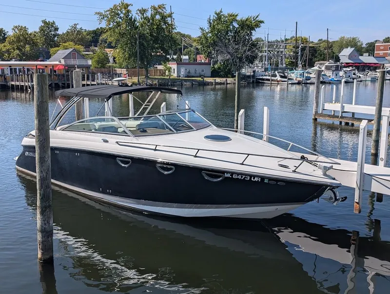 Slide: The Image of 2007 Cobalt 323 boat docked in a marina with scenic background. - 2