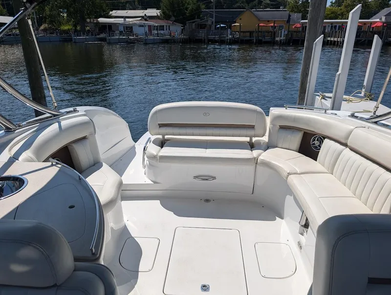 Slide: The Image of 2007 Cobalt 323 boat interior with white seating, docked by a scenic waterfront. - 25