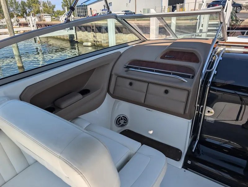 Slide: The Image of Interior of a 2007 Cobalt 323 boat with white seating and dashboard details. - 29