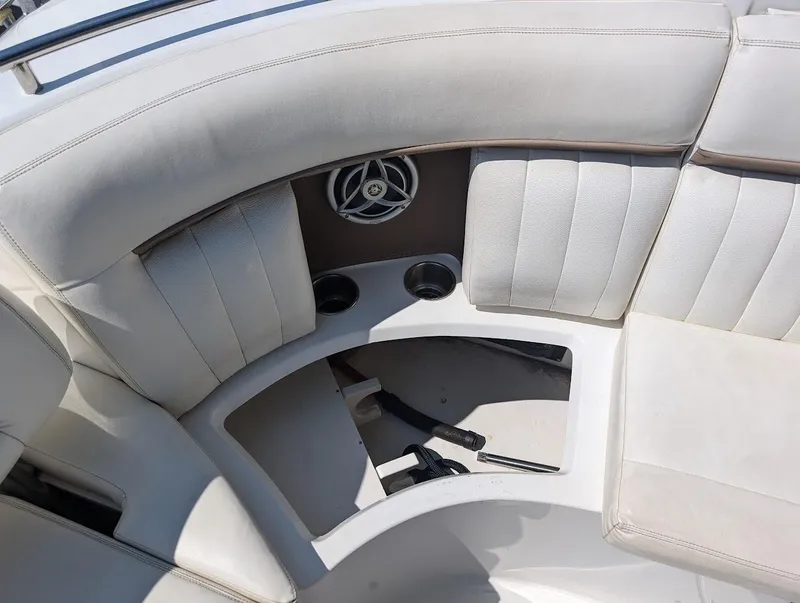 Slide: The Image of 2007 Cobalt 323 boat interior with white cushioned seating and built-in speakers. - 34