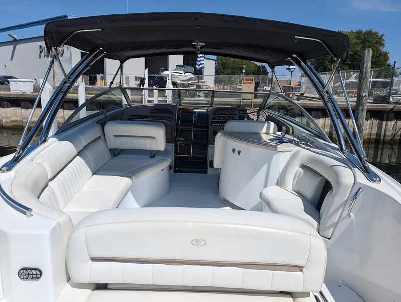 Slide: The Image of 2007 Cobalt 323 boat with spacious white seating and black canopy at a marina. - 40
