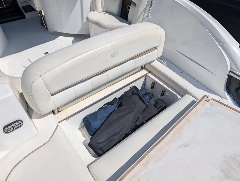 Slide: The Image of 2007 Cobalt 323 boat interior with open storage compartment and folded clothes. - 43